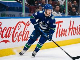 Vancouver Canucks alternate captain Elias Pettersson (number 40) skating on ice during an NHL game, controlling the puck.