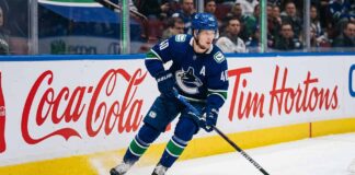 Vancouver Canucks alternate captain Elias Pettersson (number 40) skating on ice during an NHL game, controlling the puck.