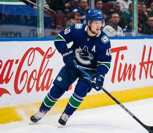 Vancouver Canucks alternate captain Elias Pettersson (number 40) skating on ice during an NHL game, controlling the puck.