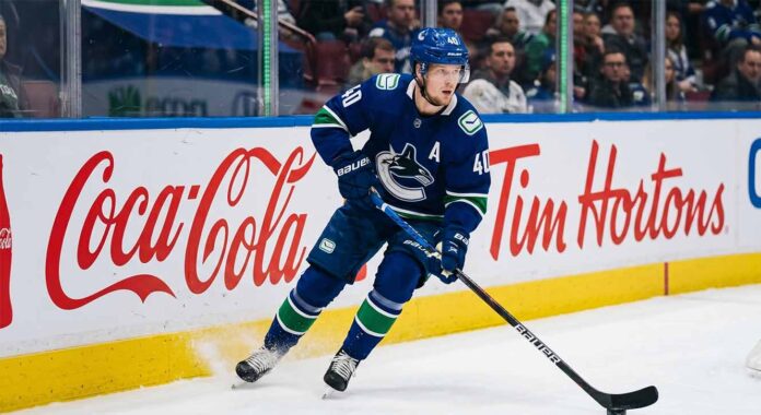 Vancouver Canucks alternate captain Elias Pettersson (number 40) skating on ice during an NHL game, controlling the puck.