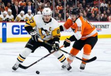 Intense puck battle between Pittsburgh Penguins captain Sidney Crosby (#87) and Philadelphia Flyers forward Travis Konecny (#11) during an NHL Stanley Cup Playoff game.