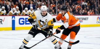 Intense puck battle between Pittsburgh Penguins captain Sidney Crosby (#87) and Philadelphia Flyers forward Travis Konecny (#11) during an NHL Stanley Cup Playoff game.