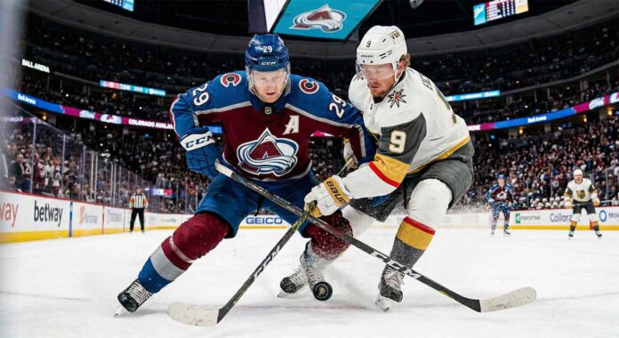 how-to-watch-avalanche-vs-golden-knights-apr-11 A dynamic photo of Colorado Avalanche center Nathan MacKinnon (#29) battling Vegas Golden Knights center Jack Eichel (#9) for puck possession during a high-stakes NHL game at Ball Arena.