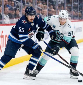 How to Watch Seattle Kraken vs. Winnipeg Jets | TV Channels & Stream Winnipeg Jets forward Mark Scheifele (55) in navy blue jersey battles for puck possession against Seattle Kraken forward Shane Wright (51) in white away jersey during a 2025-26 NHL regular season game at Canada Life Centre.