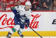 Will the Vancouver Canucks Trade Jake DeBrusk This Offseason? Jake DeBrusk of the Vancouver Canucks skating with the puck during an NHL game, a player whose offseason trade potential is a major point of discussion.