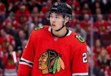 Detailed composite photo of Dallas Stars superstar forward Jason Robertson in a Chicago Blackhawks red home jersey with number 21, on the ice in a packed United Center during a game, illustrating an NHL trade rumor.