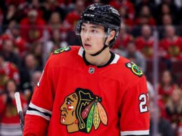 Detailed composite photo of Dallas Stars superstar forward Jason Robertson in a Chicago Blackhawks red home jersey with number 21, on the ice in a packed United Center during a game, illustrating an NHL trade rumor.