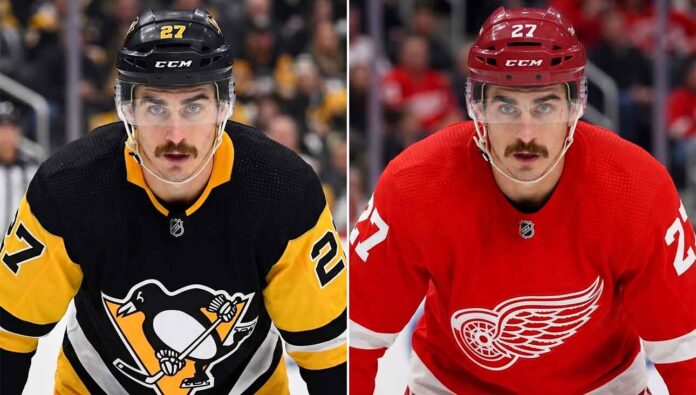 A close-up portrait of hockey player Mason Marchment with intense blue eyes and a mustache, wearing a white Seattle Kraken jersey, who is currently a pending UFA for the Columbus Blue Jackets and a target for the Pittsburgh Penguins and Detroit Red Wings in NHL free agency.