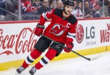 Nico Hischier Trade Rumors: Devils, Wild & Senators Analysis New Jersey Devils captain Nico Hischier skating on the ice, facing NHL trade rumors linking him to the Minnesota Wild and Ottawa Senators.