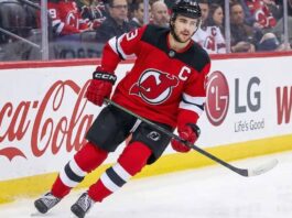 New Jersey Devils captain Nico Hischier skating on the ice, facing NHL trade rumors linking him to the Minnesota Wild and Ottawa Senators.