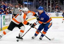Philadelphia Flyers Travis Konecny (11) and New York Islanders Mathew Barzal (13) in a fierce battle for the hockey puck during a Metropolitan Division NHL game at UBS Arena.