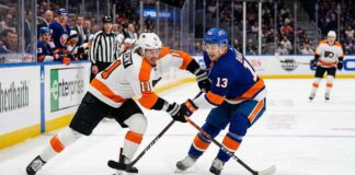 Philadelphia Flyers Travis Konecny (11) and New York Islanders Mathew Barzal (13) in a fierce battle for the hockey puck during a Metropolitan Division NHL game at UBS Arena.