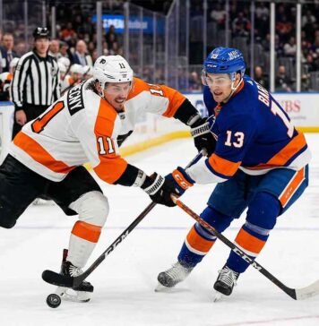 Philadelphia Flyers Travis Konecny (11) and New York Islanders Mathew Barzal (13) in a fierce battle for the hockey puck during a Metropolitan Division NHL game at UBS Arena.