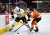 Pittsburgh Penguins center Evgeni Malkin (71) battles Philadelphia Flyers forward Travis Konecny (11) along the boards for puck possession during an intense NHL playoff game in the Battle of Pennsylvania rivalry.