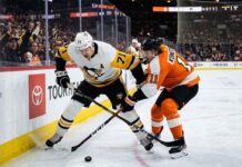 Pittsburgh Penguins center Evgeni Malkin (71) battles Philadelphia Flyers forward Travis Konecny (11) along the boards for puck possession during an intense NHL playoff game in the Battle of Pennsylvania rivalry.