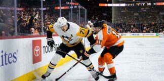 Pittsburgh Penguins center Evgeni Malkin (71) battles Philadelphia Flyers forward Travis Konecny (11) along the boards for puck possession during an intense NHL playoff game in the Battle of Pennsylvania rivalry.