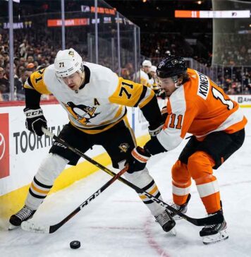 Pittsburgh Penguins center Evgeni Malkin (71) battles Philadelphia Flyers forward Travis Konecny (11) along the boards for puck possession during an intense NHL playoff game in the Battle of Pennsylvania rivalry.