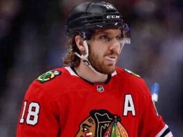 Concept image of Robert Thomas wearing a red Chicago Blackhawks jersey amidst NHL trade rumors involving a blockbuster deal with the St. Louis Blues.