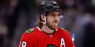 Concept image of Robert Thomas wearing a red Chicago Blackhawks jersey amidst NHL trade rumors involving a blockbuster deal with the St. Louis Blues.