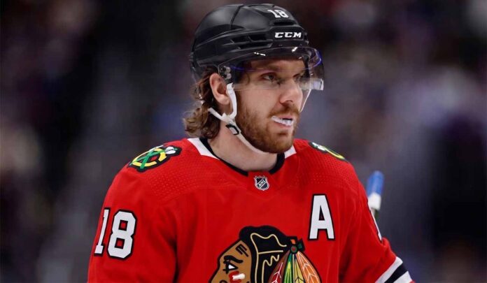 Concept image of Robert Thomas wearing a red Chicago Blackhawks jersey amidst NHL trade rumors involving a blockbuster deal with the St. Louis Blues.