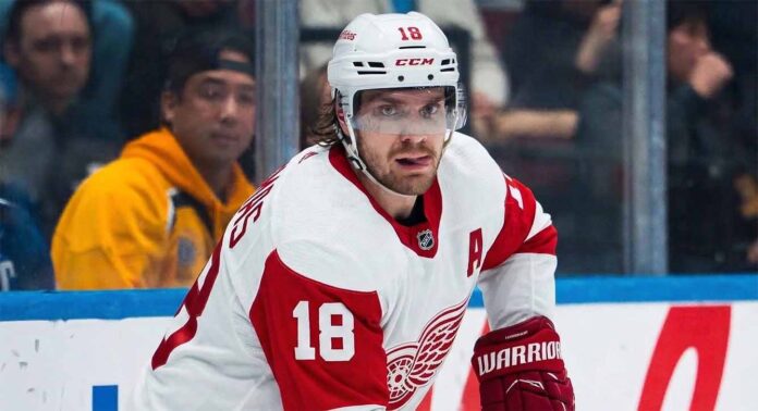 robert-thomas-detroit-red-wings-trade-blues St. Louis Blues center Robert Thomas (wearing jersey number 18 and a white helmet with a clear visor) looking intense during an NHL game. He is a reported blockbuster trade target for the Detroit Red Wings to fix their 5v5 scoring and end their playoff drought.