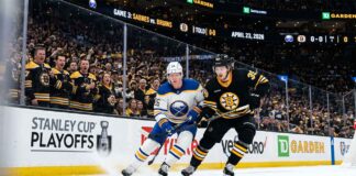 A dynamic photo of Buffalo Sabres and Boston Bruins players battling on the ice during Game 3 of the Stanley Cup Playoffs at TD Garden on April 23, 2026.