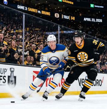 A dynamic photo of Buffalo Sabres and Boston Bruins players battling on the ice during Game 3 of the Stanley Cup Playoffs at TD Garden on April 23, 2026.