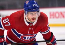 Realistic photo rendering of hockey player Sidney Crosby wearing a red Montreal Canadiens jersey with the captain’s ‘C’ patch, illustrating NHL trade rumors between the Pittsburgh Penguins and Canadiens.