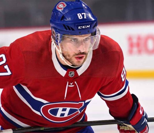 Realistic photo rendering of hockey player Sidney Crosby wearing a red Montreal Canadiens jersey with the captain’s ‘C’ patch, illustrating NHL trade rumors between the Pittsburgh Penguins and Canadiens.