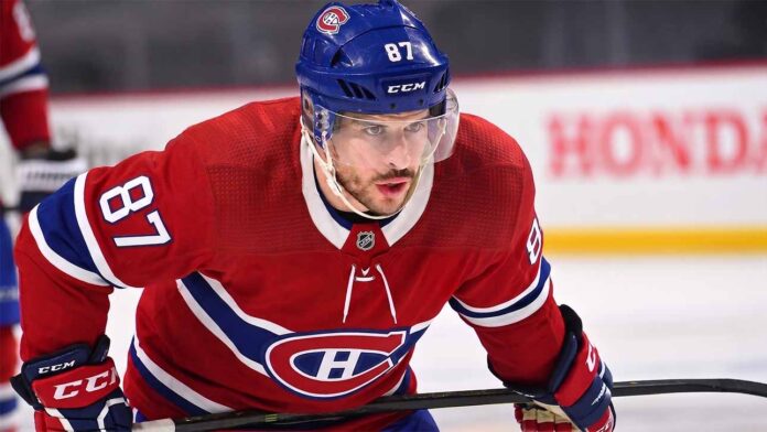 Realistic photo rendering of hockey player Sidney Crosby wearing a red Montreal Canadiens jersey with the captain’s ‘C’ patch, illustrating NHL trade rumors between the Pittsburgh Penguins and Canadiens.