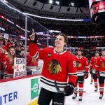 Connor Bedard celebrating on the ice with a sign stating "BEDARD #1 JERSEY SELLER," highlighting his position as the player with the top selling NHL jersey for the 2025-26 regular season.