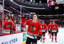 Connor Bedard celebrating on the ice with a sign stating "BEDARD #1 JERSEY SELLER," highlighting his position as the player with the top selling NHL jersey for the 2025-26 regular season.