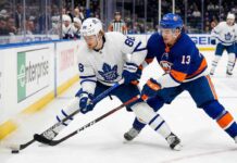 Action shot of Toronto Maple Leafs forward William Nylander battling New York Islanders center Mathew Barzal for the puck during an NHL regular season game.