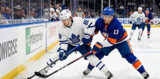 Action shot of Toronto Maple Leafs forward William Nylander battling New York Islanders center Mathew Barzal for the puck during an NHL regular season game.