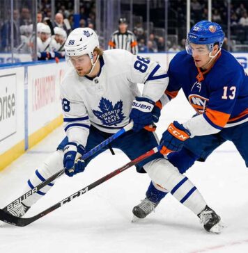 Action shot of Toronto Maple Leafs forward William Nylander battling New York Islanders center Mathew Barzal for the puck during an NHL regular season game.