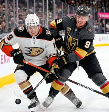 Cutter Gauthier of the Anaheim Ducks and Jack Eichel of the Vegas Golden Knights battle for the puck during Game 1 of their 2026 NHL Playoff series at T-Mobile Arena.