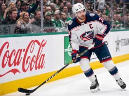 Will Boone Jenner Leave the Columbus Blue Jackets in Free Agency? Columbus Blue Jackets captain Boone Jenner (38) in a white away jersey looking focused on the ice while handling the puck.