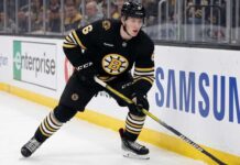 Boston Bruins Trade Rumors: Will Mason Lohrei Be Traded for a Top-Six Forward? Boston Bruins defenseman Mason Lohrei looks to advance the puck during a game. Lohrei, wearing jersey number 6, is the subject of recent NHL trade rumors suggesting he could be moved for a top-six forward.