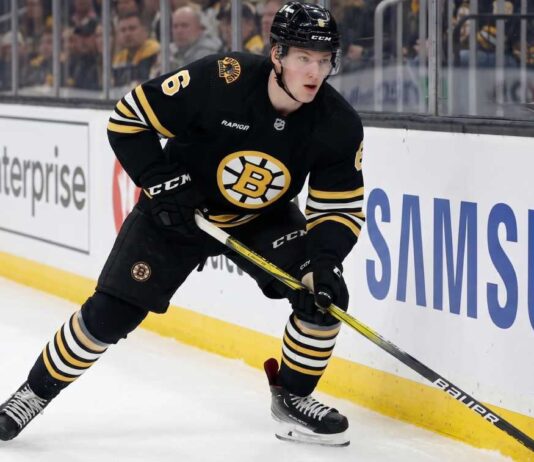 Boston Bruins Trade Rumors: Will Mason Lohrei Be Traded for a Top-Six Forward? Boston Bruins defenseman Mason Lohrei looks to advance the puck during a game. Lohrei, wearing jersey number 6, is the subject of recent NHL trade rumors suggesting he could be moved for a top-six forward.