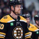 Photo manipulation showing Vancouver Canucks center Elias Pettersson wearing a black Boston Bruins home jersey and helmet, visualizing a potential blockbuster trade scenario.