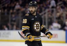 Conceptual photo of New York Rangers center Vincent Trocheck wearing a black Boston Bruins home jersey, number 16, holding a hockey stick on the ice.