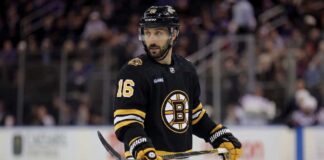 Boston Bruins Trade Rumors: Will They Acquire Vincent Trocheck? Conceptual photo of New York Rangers center Vincent Trocheck wearing a black Boston Bruins home jersey, number 16, holding a hockey stick on the ice.