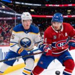 An intense moment on the ice during the Buffalo Sabres and Montreal Canadiens Game 6 matchup as Sabres defenseman Rasmus Dahlin (#26) and Canadiens captain Nick Suzuki (#14) battle fiercely for the puck at Centre Bell.