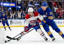 Montreal Canadiens Alex Newhook (18) and Buffalo Sabres Rasmus Dahlin (26) battle for a puck in Game 7.