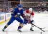 Tage Thompson #72 of the Buffalo Sabres and Nick Suzuki #14 of the Montreal Canadiens intensely battle for the puck on the ice during an NHL playoff game.