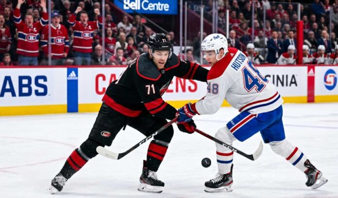 NHL hockey game faceoff at Bell Centre: Carolina Hurricanes forward Taylor Hall #71 and Montreal Canadiens defenseman Lane Hutson #48 prepare for puck drop during the NHL playoffs.
