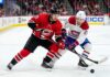 How to Watch Carolina Hurricanes vs Montreal Canadiens Game 4 Today Carolina Hurricanes’ Sebastian Aho (jersey 20) and Montreal Canadiens’ Lane Hutson (jersey 21) battle intensely for a hockey puck on the ice during Game 4 of the 2026 Eastern Conference Final. Both players are low to the ice, locking sticks over the puck, with a crowded arena and hockey boards visible in the background.