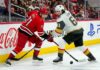 Carolina Hurricanes forward Taylor Hall takes a face-off against Vegas Golden Knights captain Mark Stone during the Stanley Cup Final, with Coca-Cola and PS5 ads visible on the boards.