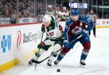 Minnesota Wild star Kirill Kaprizov (#97) engages in an intense board battle for the puck with Colorado Avalanche captain Nathan MacKinnon (#29) during Game 4 of their NHL playoff series at Xcel Energy Center on Monday, May 11, 2026.