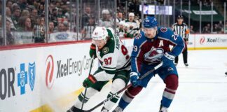 Minnesota Wild star Kirill Kaprizov (#97) engages in an intense board battle for the puck with Colorado Avalanche captain Nathan MacKinnon (#29) during Game 4 of their NHL playoff series at Xcel Energy Center on Monday, May 11, 2026.